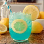 Glass of blue lemonade with lemon slices and ice cubes